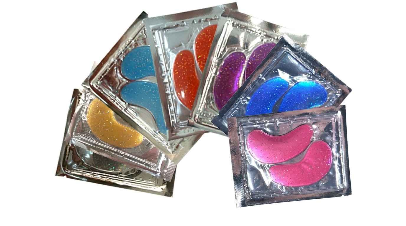 Multiple colorful hydrogel under-eye patch sachets fanned out on white surface